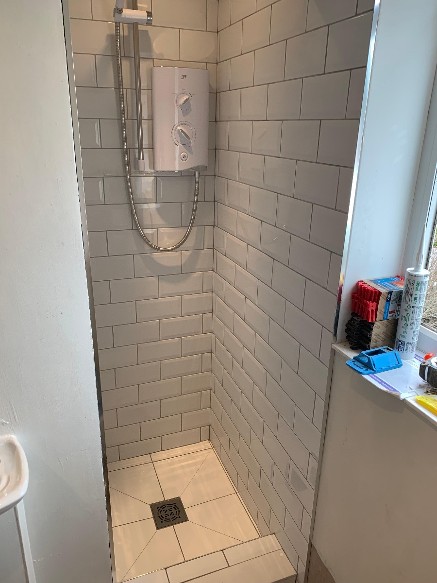 Walk-in wet room with frameless glass screen and rainfall shower