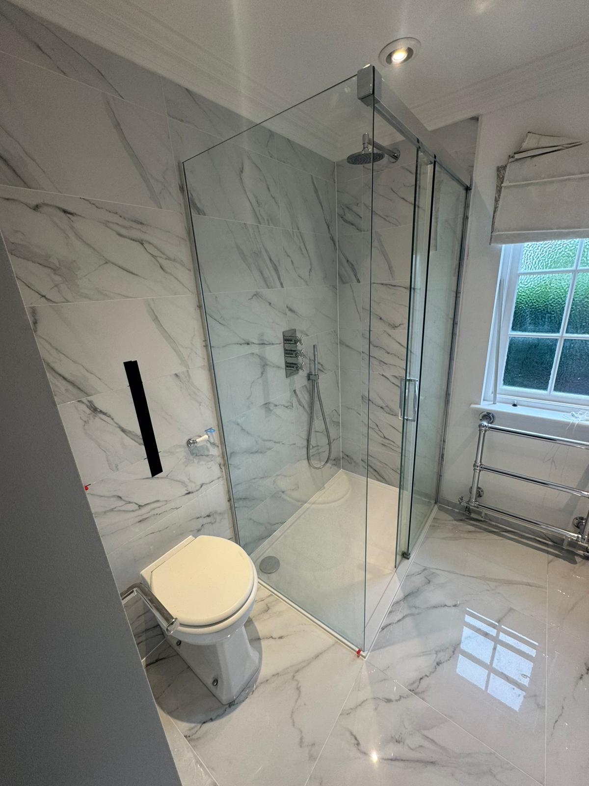 Finished marble bathroom with walk-in shower and double vanity after a leak repair and re-tile by Adsett Bathrooms in West Sussex