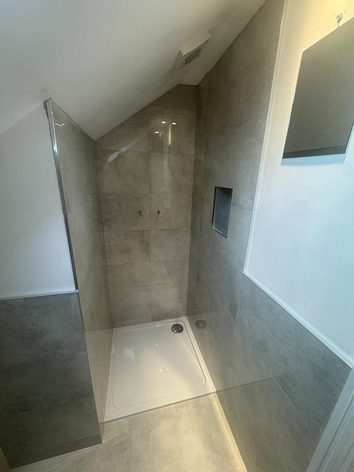 Tiled loft shower enclosure with recessed niche and white shower tray in West Sussex