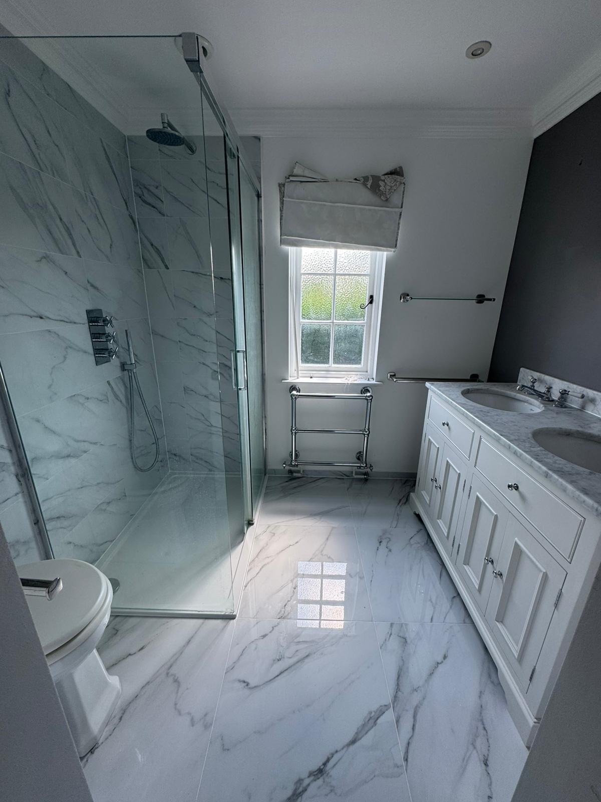 Re-tiled marble walk-in shower with chrome fittings after a leak repair by Adsett Bathrooms in West Sussex