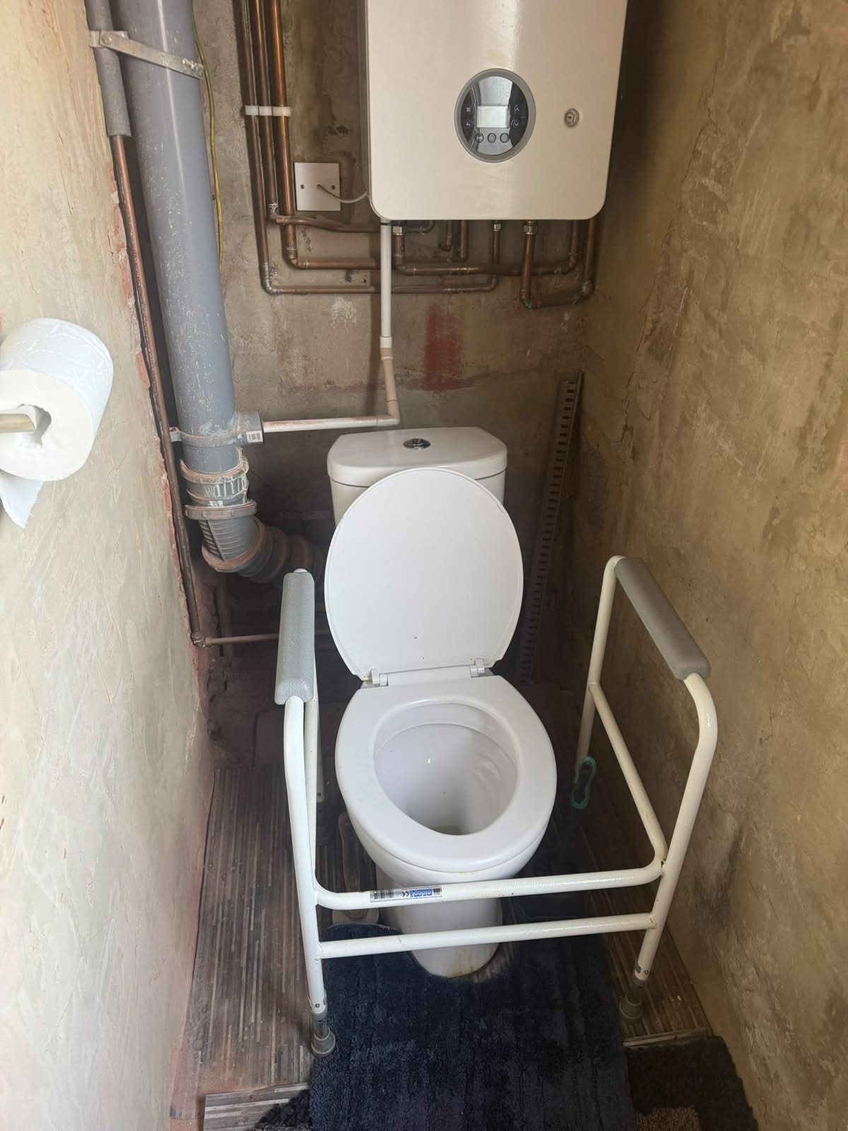 Old standard-height toilet with a free-standing toilet frame, before replacement by Adsett Bathrooms in West Sussex