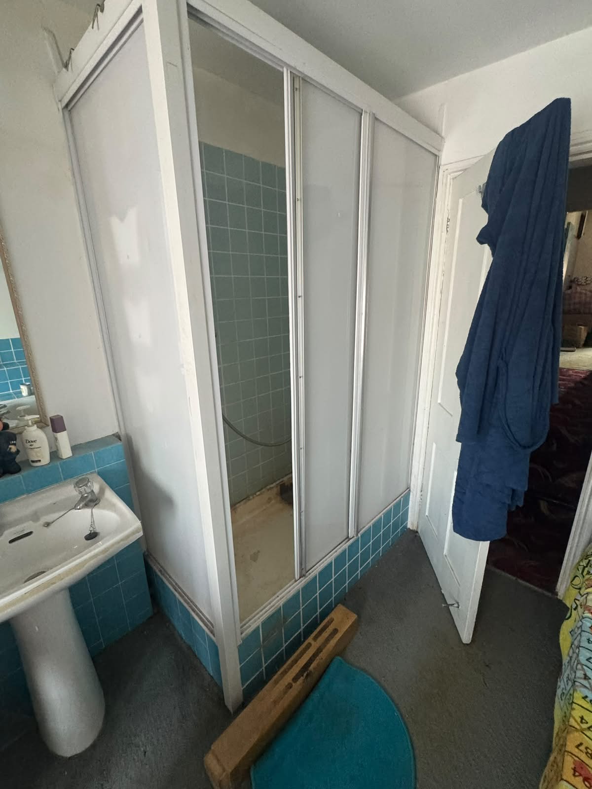 Old shower cubicle on a raised tiled step, before replacement by Adsett Bathrooms in West Sussex