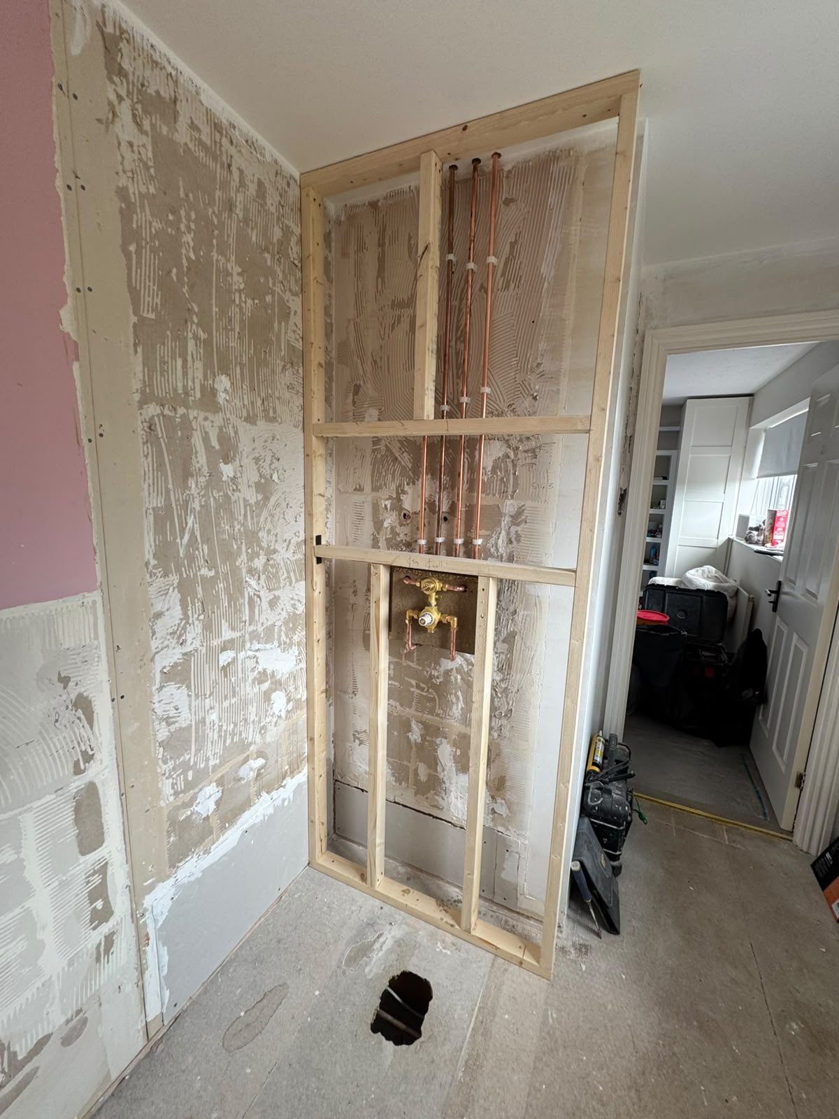 Timber stud work and copper pipework housing the new shower valve during a West Sussex shower installation