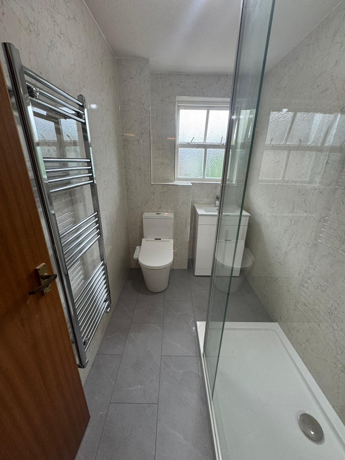 Finished walk-in shower conversion with marble-effect wall panels and easy-access shower by Adsett Bathrooms in West Sussex