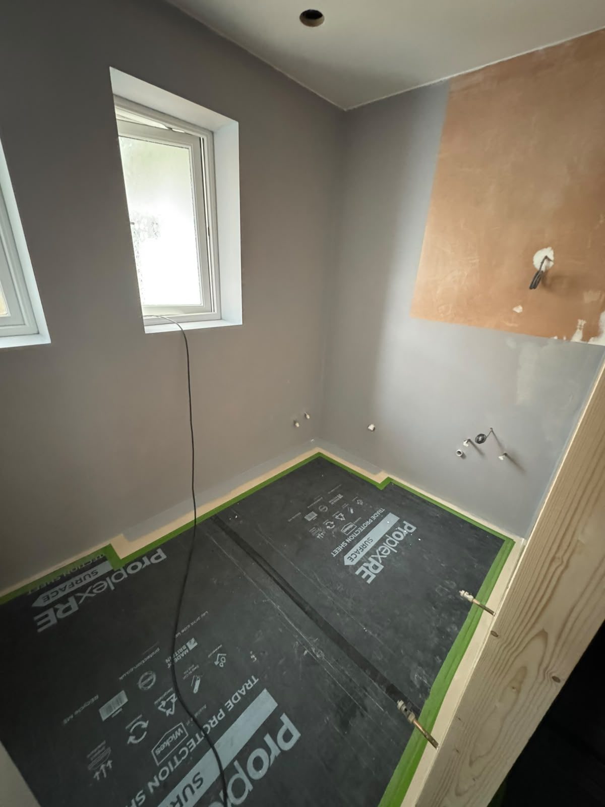 Re-plastered bathroom walls prepared before stone-effect panelling